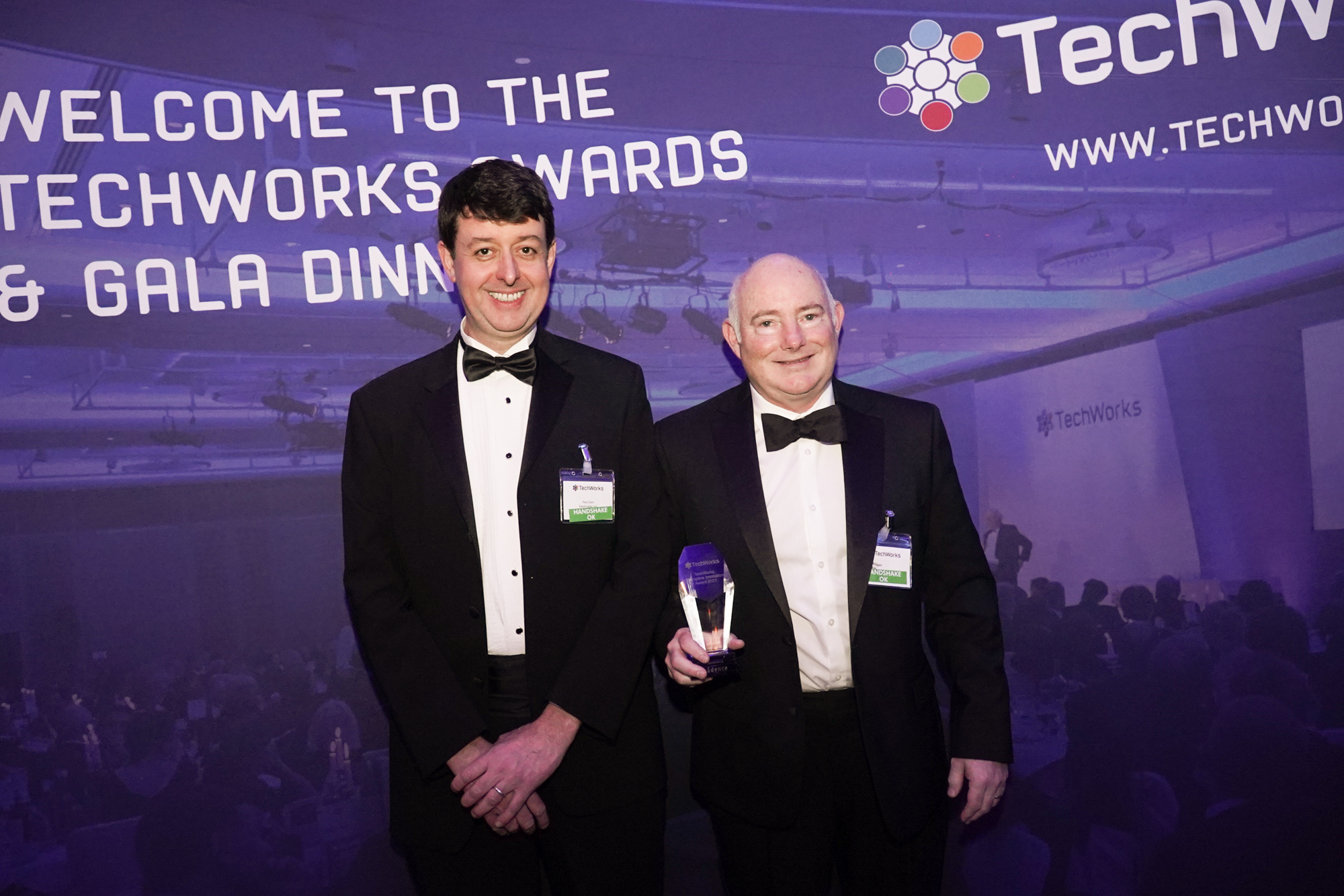 FlexEnable’s CEO, Chuck Milligan (right), and Strategy Director, Paul Cain, receive the 2021 TechWorks Disruptive Innovation Award